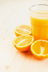 Glass of freshly pressed orange juice with sliced orange halfs
