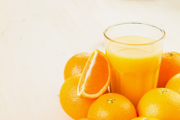 Glass of freshly pressed orange juice with oranges