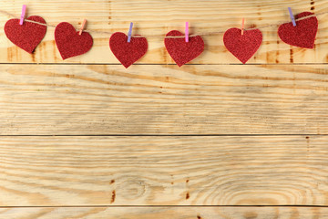 A garland of hearts on clothespins on a natural wooden background. view from above . space for text