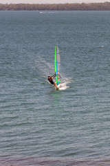Fifty years plus male on short board windsurfing from the shores of Lake Macquarie in a summer north easterly breeze, Australia
