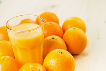 Glass of freshly pressed orange juice with oranges