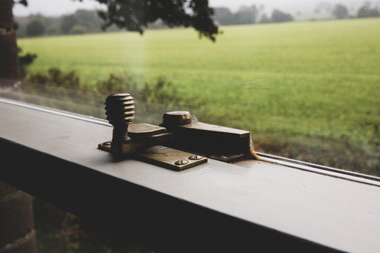 Close up of brass latch on sash window.