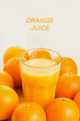 Glass of freshly pressed orange juice with oranges