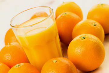 Glass of freshly pressed orange juice with oranges