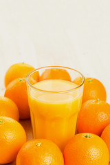 Glass of freshly pressed orange juice with oranges