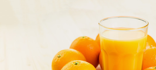 Glass of freshly pressed orange juice with oranges