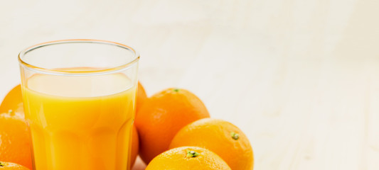 Glass of freshly pressed orange juice with oranges