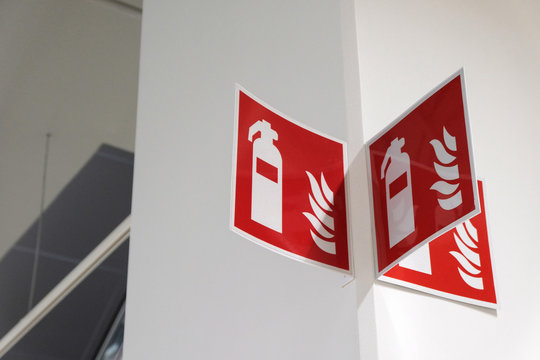 Fire extinguisher sign on the white wall.