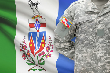 American soldier with Canadian province flag on background - Yukon