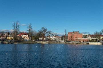 Winter landscape sunny afternoon house on the lake on a blue background