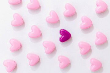 Pink beads in heart shape stacked on  table with copy space. Sweet beads for love theme on Valentine concept in vintage style.  For background or wallpaper decor. Soft Focus