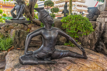 Statues of hermit at showing a posture of massage therapy at Temple of Reclining Buddha or Wat Pho,...