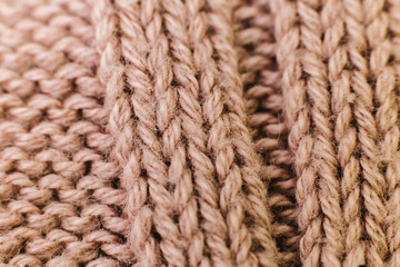 Texture of knitted woolen brown fabric for wallpaper and an abstract background. Soft focus