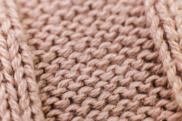 Texture of knitted woolen brown fabric for wallpaper and an abstract background. Soft focus