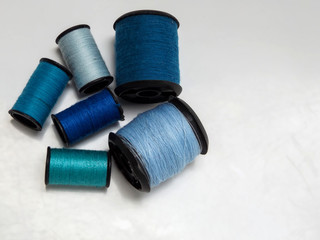 Blue spools of thread on white background with copy space