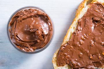 hazelnut cream sandwich breakfast and ingredients on white cutting board, black wooden table background