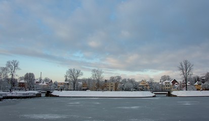 Winter landscape on the lake shore on a sunny day with snow and blue sky