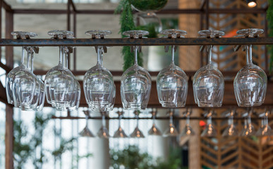 Empty glasses for wine above a bar rack in restaurant