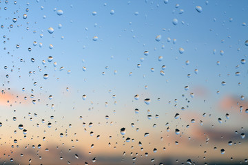 Rain drops on window with blured background.