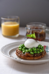 Wholemeal Bread Toast with Poached Egg and Peas. Orange Juice and onion jam on background