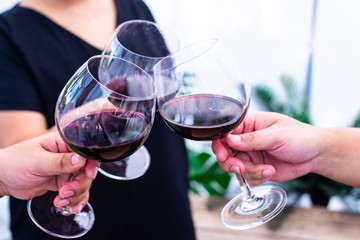 Three people toasting wine glasses