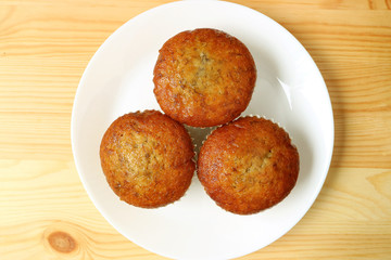 Top View of Banana Muffins on White Plate Served on Wooden Table 