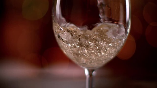 Super slow motion of pouring white wine into glass. Filmed on high speed cinema camera, 1000 fps.