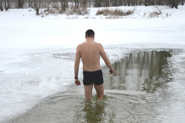 The man a walrus do improving swimming in the winter in an ice-hole in the park