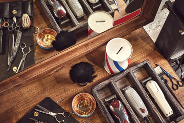 Hairdresser tools on wooden background. Top view on wooden table with scissors, comb, hairbrushes and hairclips, trimmer.