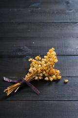 dried lily of the valley flowers on black wood table background