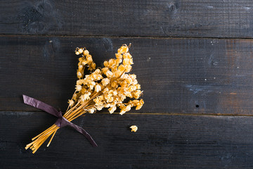 dried lily of the valley flowers on black wood table background