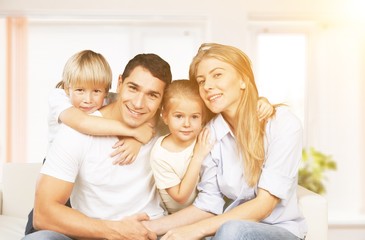 Obraz premium Beautiful smiling family sitting at sofa