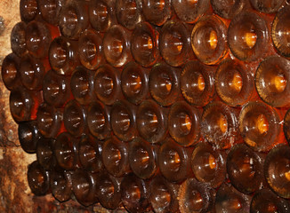 Rows of backlit wine bottles in winery cellar