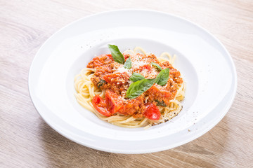spaghetti bolognese with veal and basil leaves