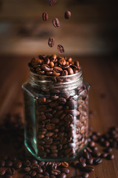 Close-up of coffee beans in a glass jar on wooden background