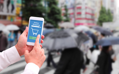 Online shopping concept. Close-up of hands using touch screen smartphone in raining season