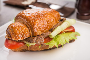 Closeup of tasty croissant with meat and cheese