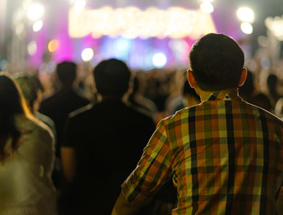 Crowd at concert , Cheering crowd in front of bright colorful stage lights , Men watching a concert