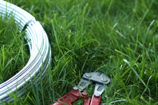 Bolt cutter near the coil wire on the grass