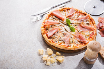 Hot pizza with prosciutto meat, tomato and mushrooms