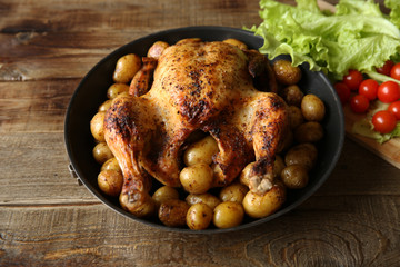 roasted chicken with vegetables on the wooden table