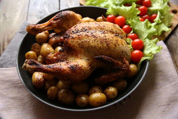 roasted chicken with vegetables on the wooden rustic table