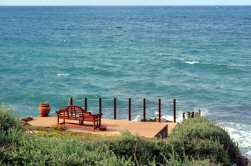 red bench on the seashore to admire beautiful landscapes