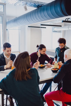Serious coworkers eating at the table in the office