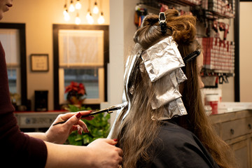 Side view of hair color and highlight process with foils for education or website
