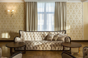Classic interior of room with beige sofa.