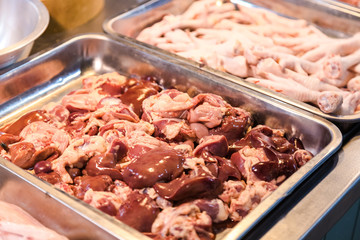 Chicken organ in tray for sell at market with chicken feet beside