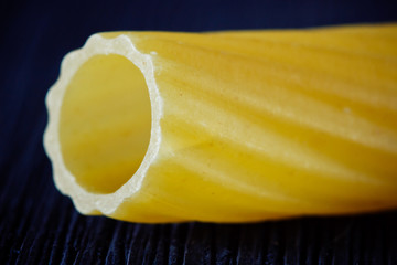 Pasta in the form of a tube close up on a black background