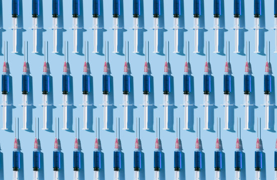 Multiple syringes organized in a pattern over blue background