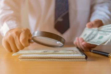 Man's hands holding Magnifying glass Financial analysis, auditing or accounting - financial health care